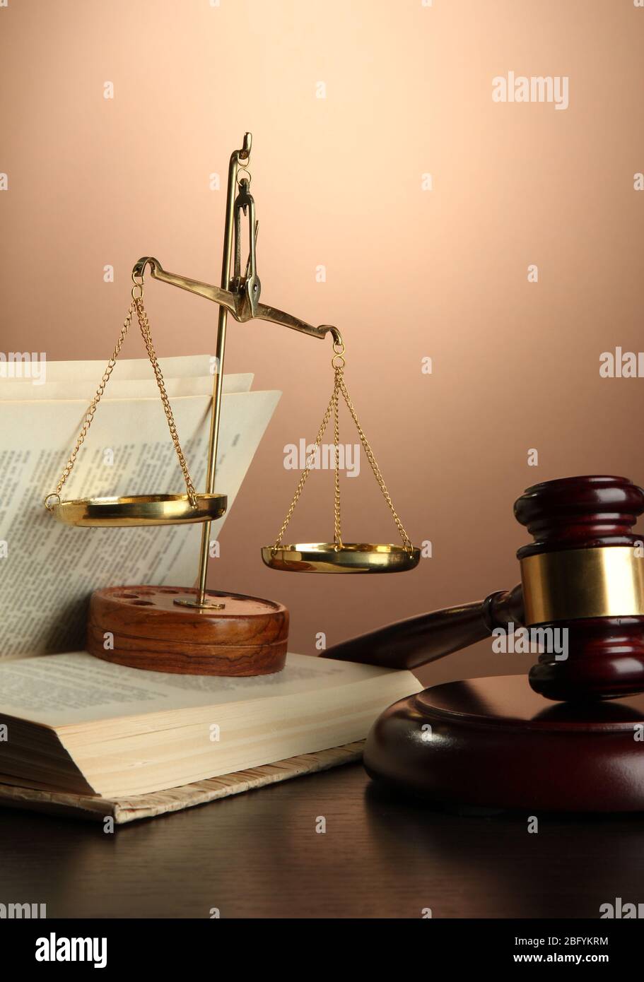 Golden scales of justice, gavel and books on brown background Stock ...