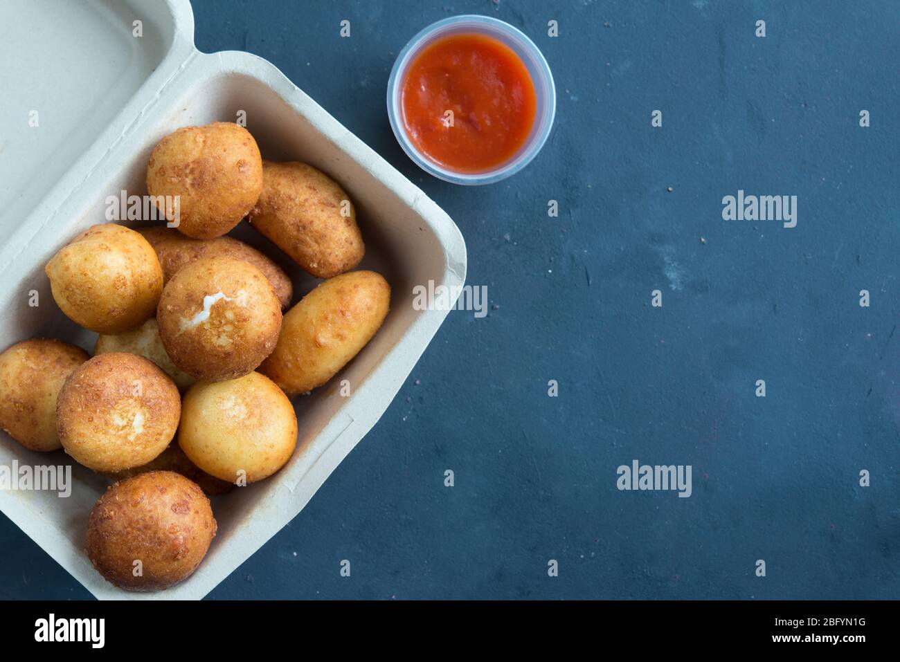 Fried Risotto Arancini stuffed with cheese, served with tomato sauce Stock Photo