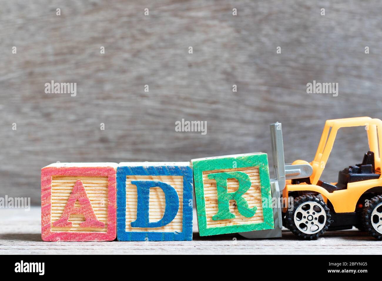 Toy Forklift Hold Letter Block R To Complete Word ADR Abbreviation Of Adverse Drug Reaction On 