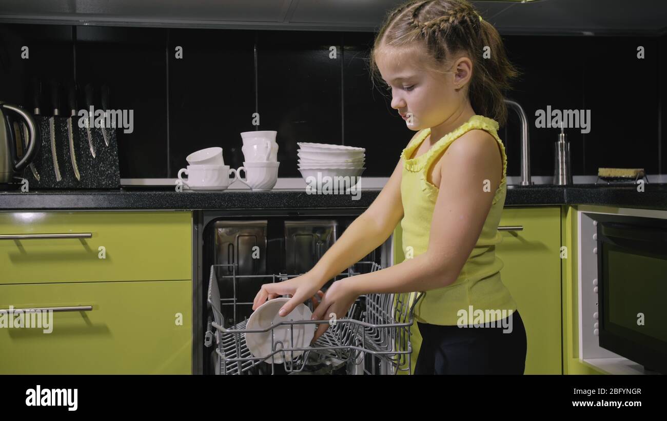https://c8.alamy.com/comp/2BFYNGR/smart-girl-learning-to-use-dishwasher-stylish-modern-built-in-kitchen-appliances-in-green-black-child-is-putting-dirty-dishes-2BFYNGR.jpg