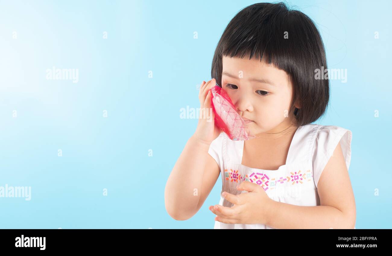Cute Asian girls are using ice bags. Apply on the cheek to reduce toothache, sore, swelling from