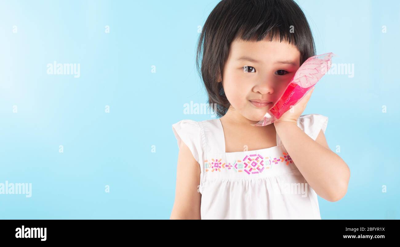 Cute Asian girls are using ice bags. Apply on the cheek to reduce toothache, sore, swelling from