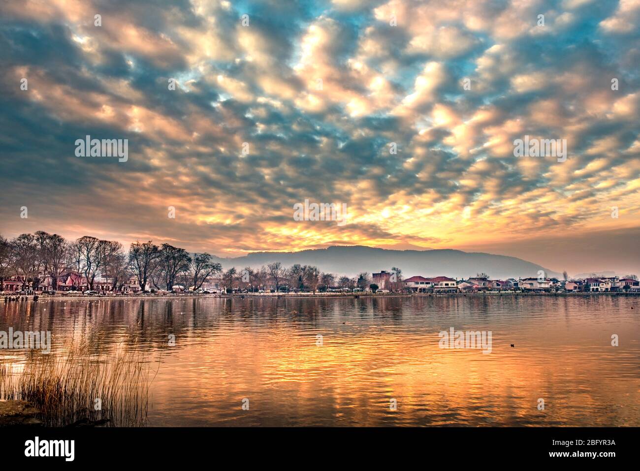 Dramatic sunset over the lake Pamvotis at Ioannina city in Greece Stock Photo