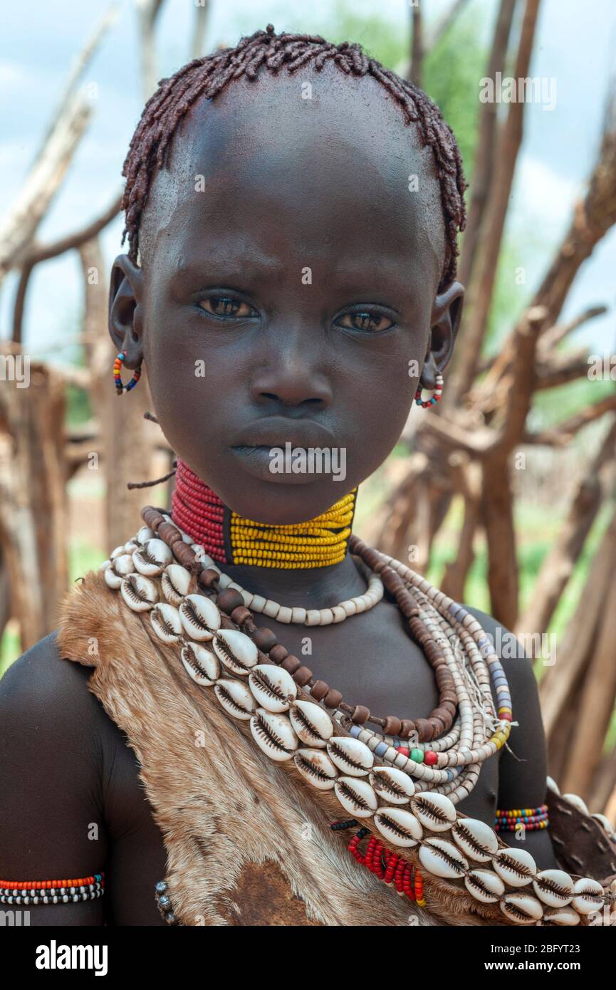 Omo Valley - Ethiopia - Africa, January 2nd, 2013: Young unidentified girl of the Hamer Tribe standing portrait with traditionall ornaments In Omo Val Stock Photo