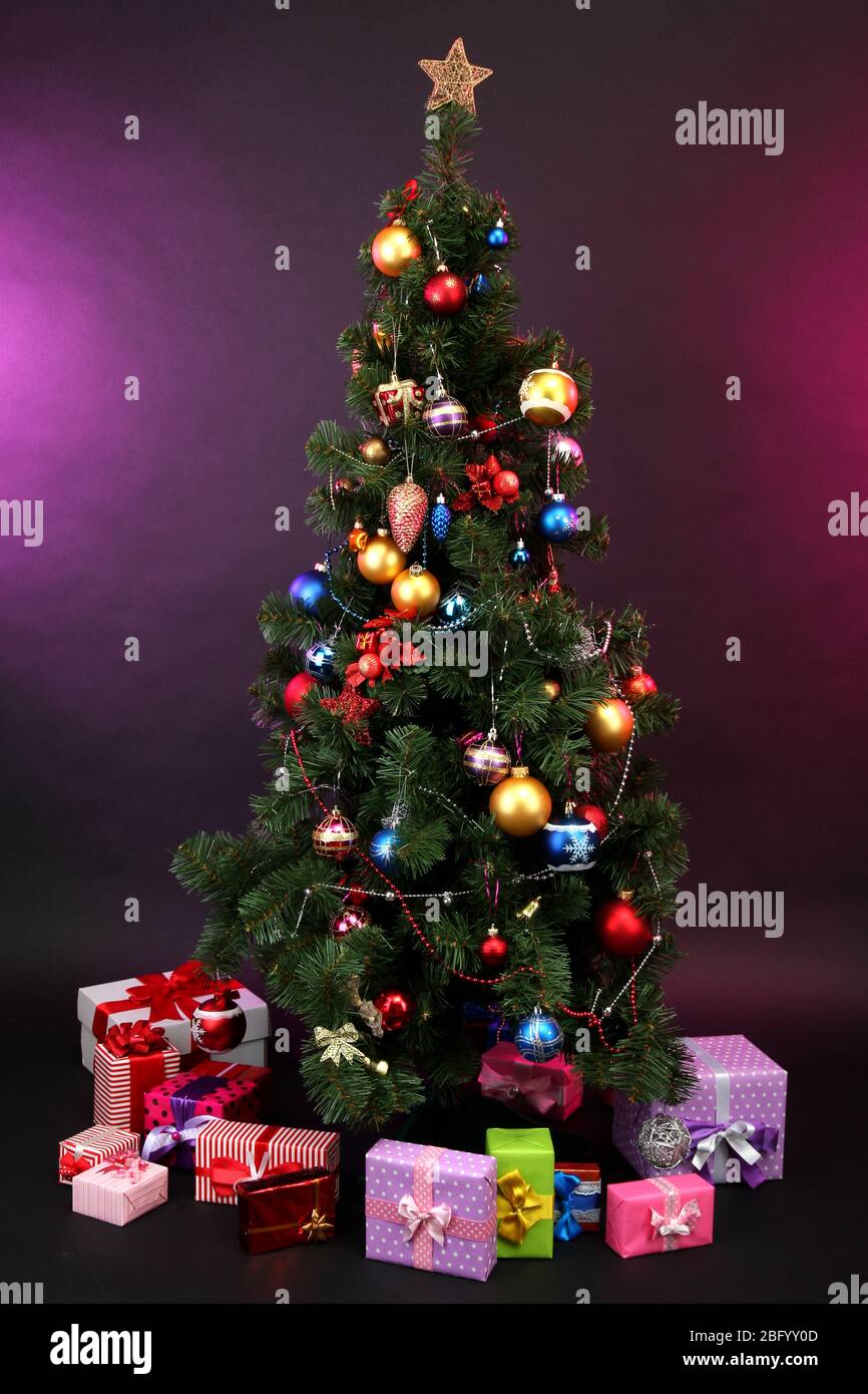 Decorated Christmas tree with gifts on dark color background Stock ...