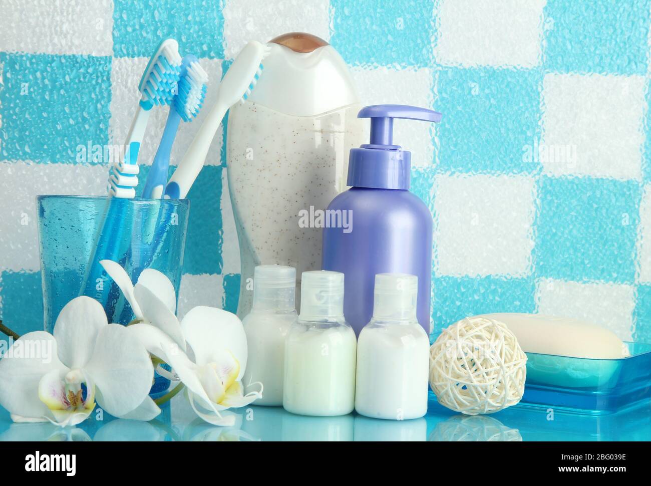 Bath accessories on shelf in bathroom on blue tile wall background ...