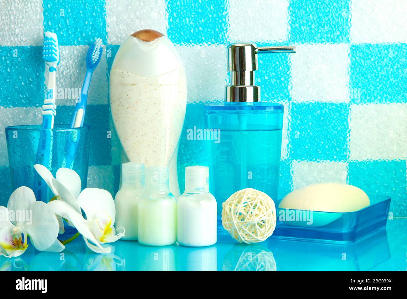 Bath accessories on shelf in bathroom on blue tile wall background ...