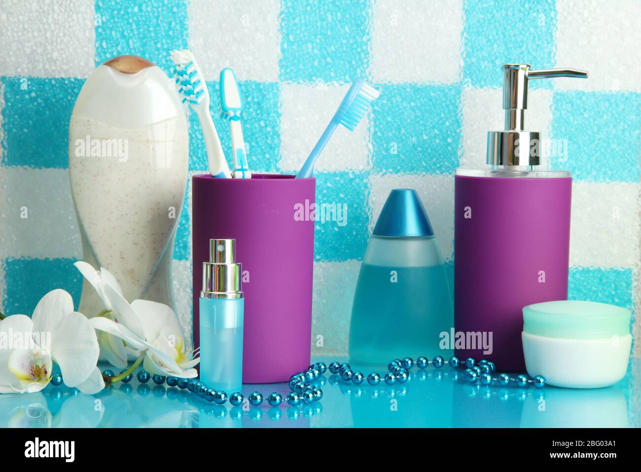 Bath accessories on shelf in bathroom on blue tile wall background ...
