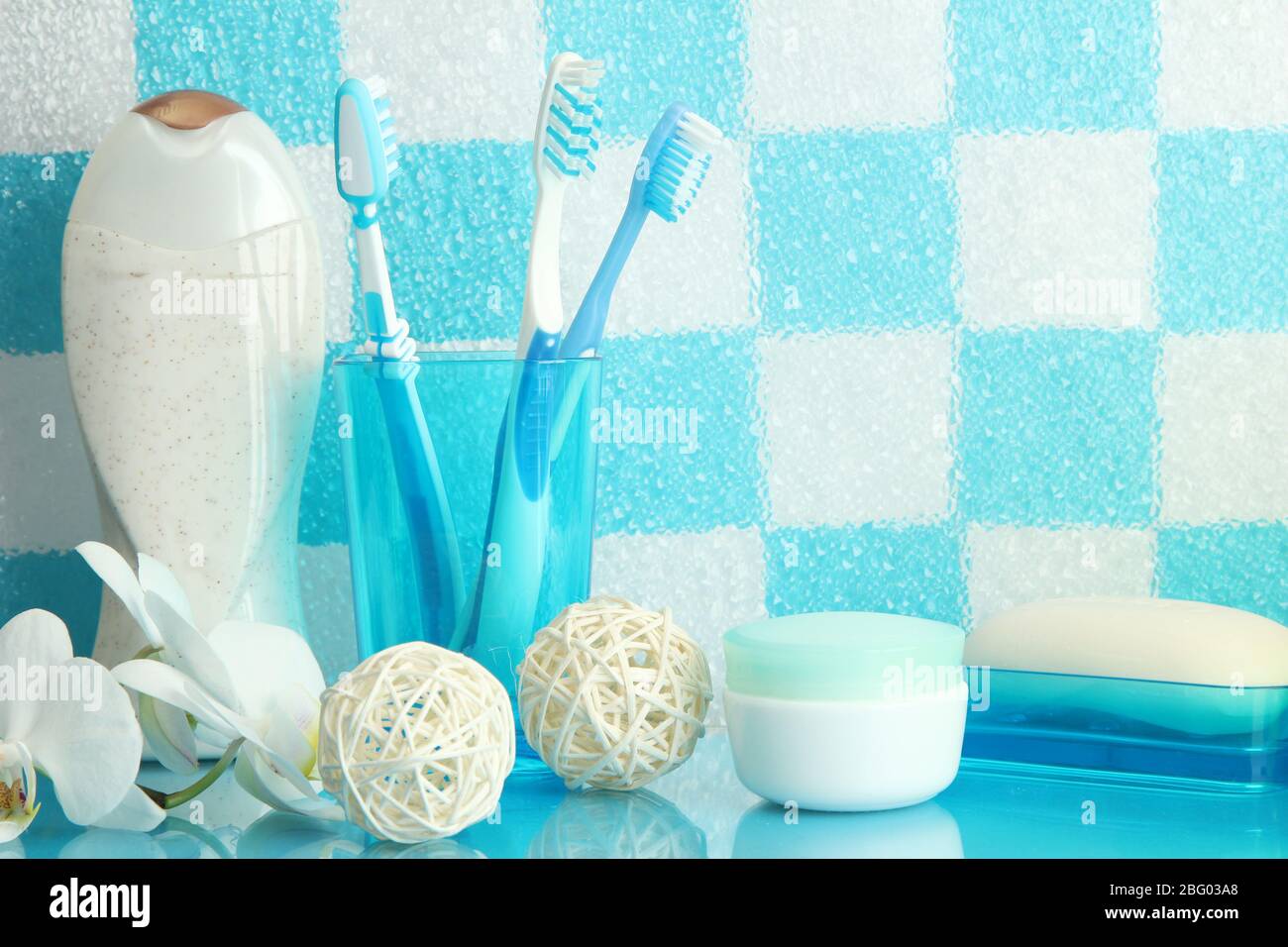 Bath accessories on shelf in bathroom on blue tile wall background ...