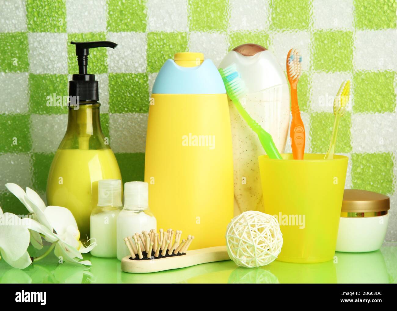 Bath accessories on shelf in bathroom on green tile wall background ...