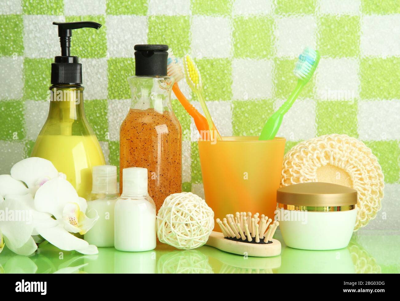Bath accessories on shelf in bathroom on green tile wall background ...