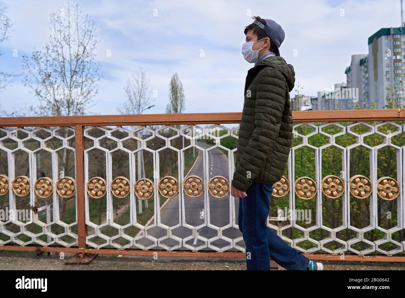 Image showcasing teen boy walks down the street during the day, a pedestrian walkway and ...