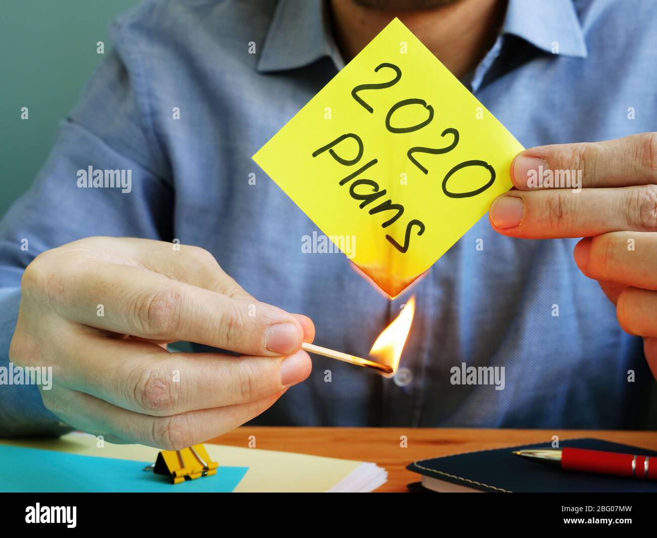 Man burns 2020 plans. Coronavirus covid-2019 and bankruptcy concept. Stock Photo