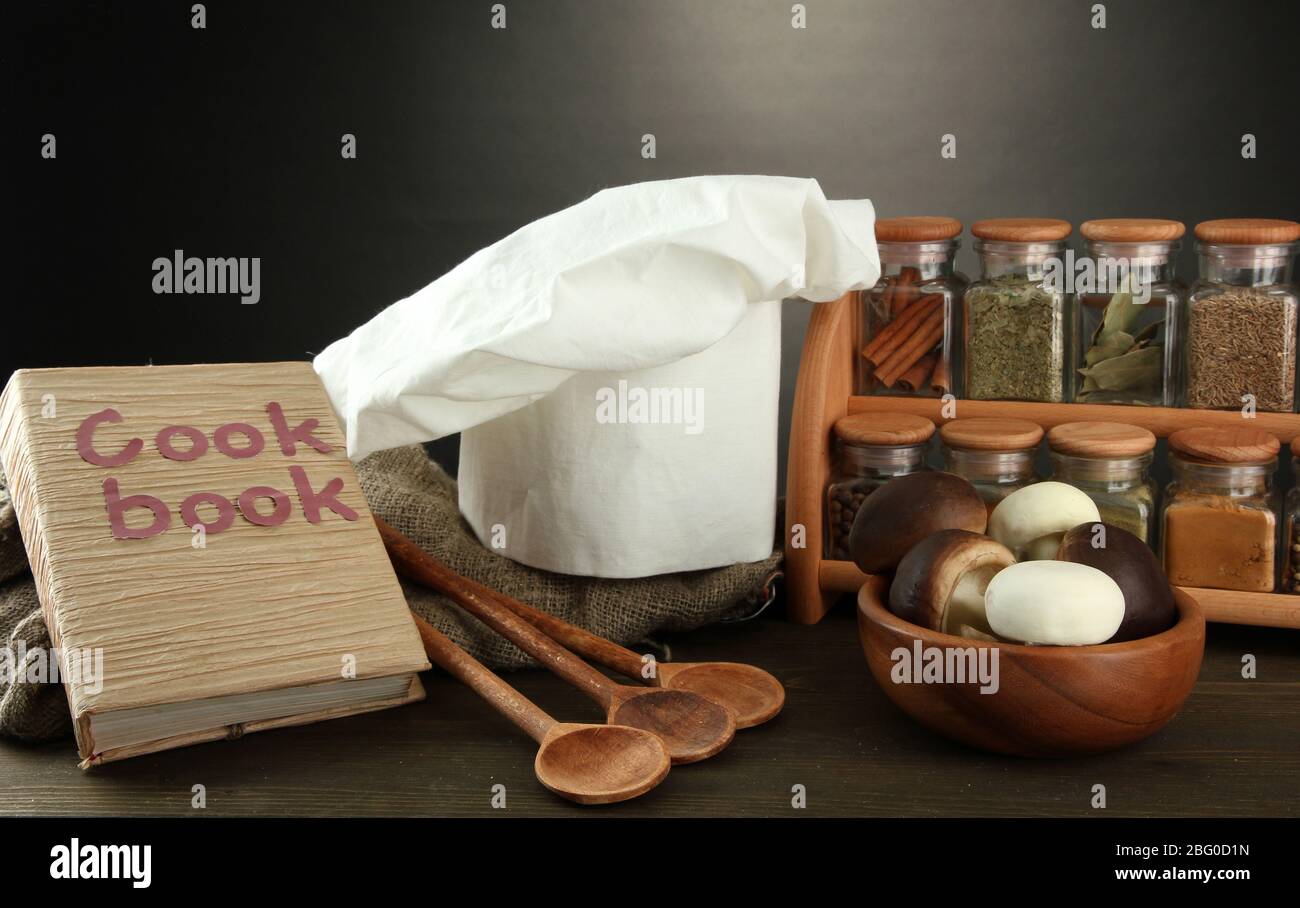 Composition with chef's hat and kitchenwear on table on grey background Stock Photo