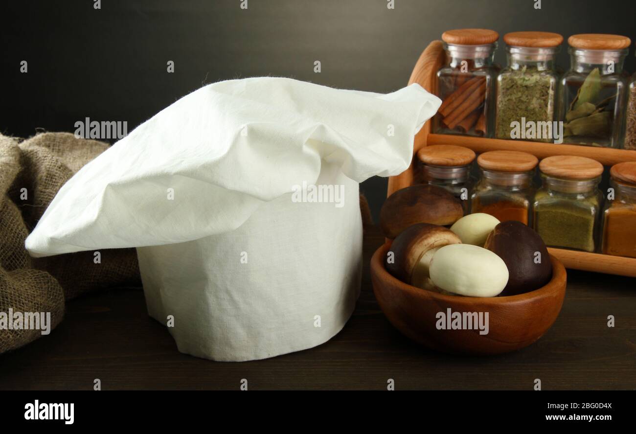 Composition with chef's hat and kitchenwear on table on grey background Stock Photo