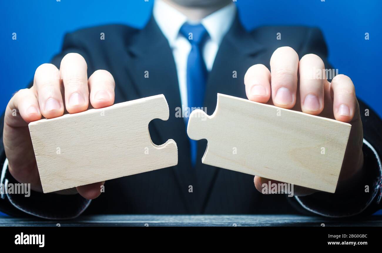 Businessman holds in hands two empty pieces of the puzzle. Business management, planning strategy. Two things for success. The process of connection i Stock Photo