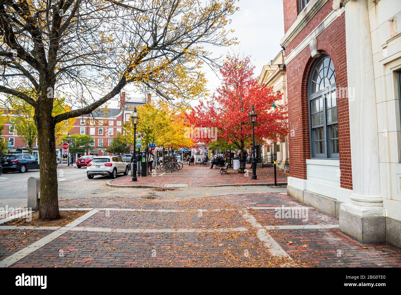 Cowd of people in a small brick square lined with colourful trees along Pleasant Street in downtown Portsmoutn, NH. Stock Photo