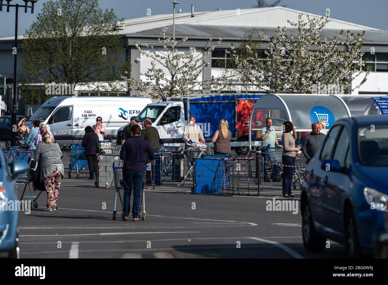 Shoppers wait outside the Tesco Superstore in Cheltenham whilst
