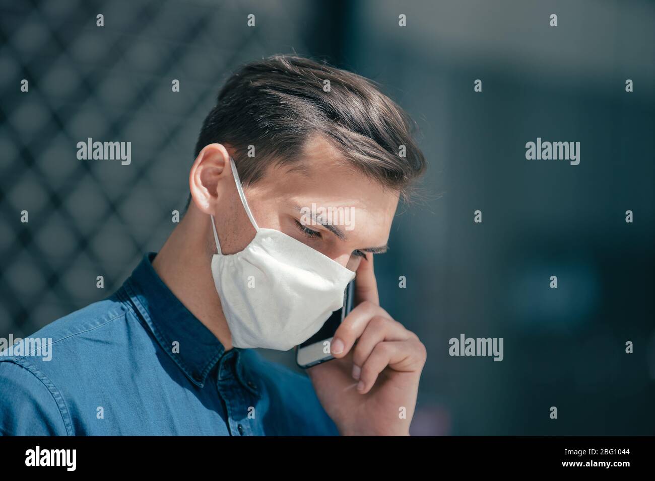 young man in a protective mask talking on a smartphone Stock Photo - Alamy