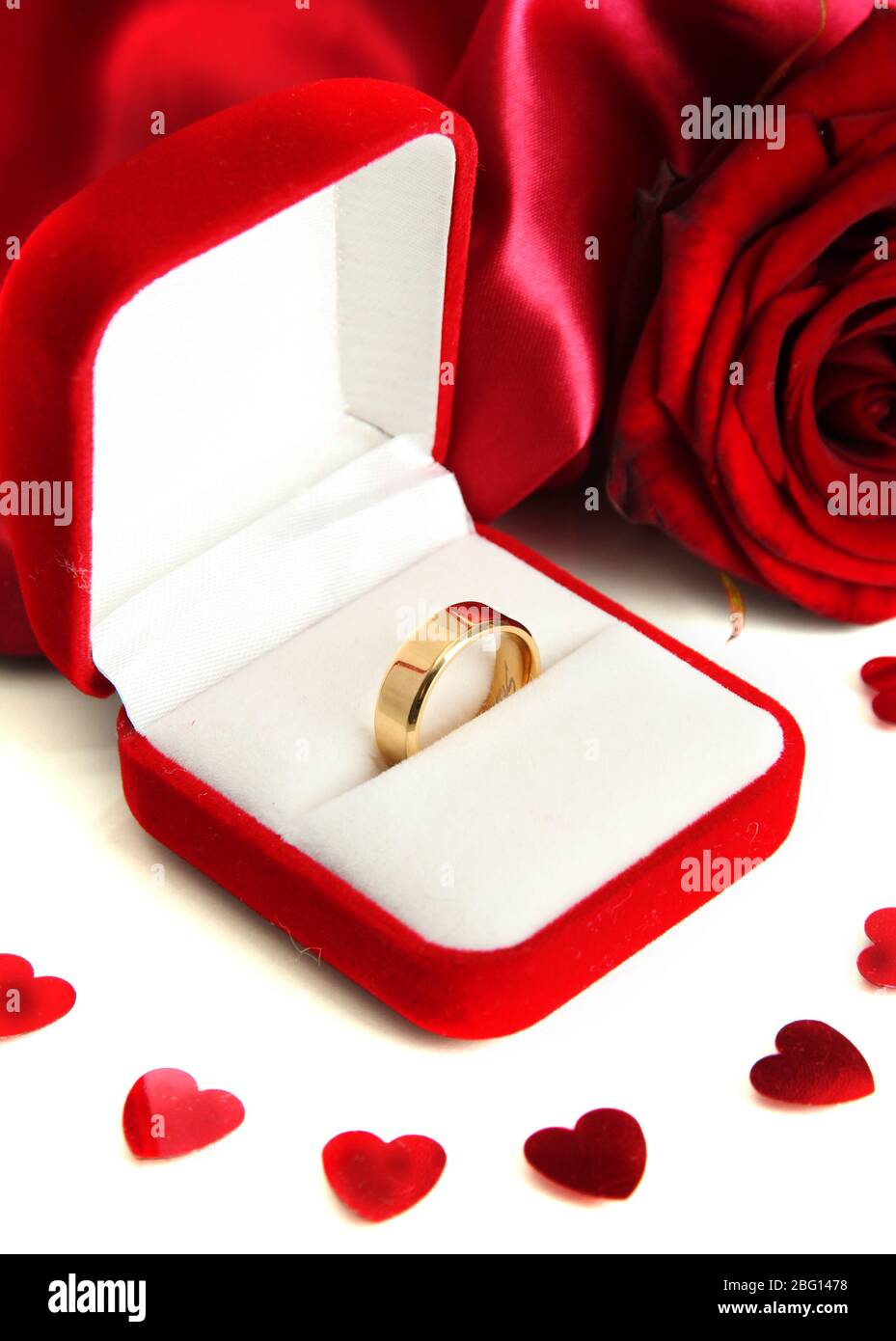 Beautiful box with wedding ring and rose on red silk background Stock