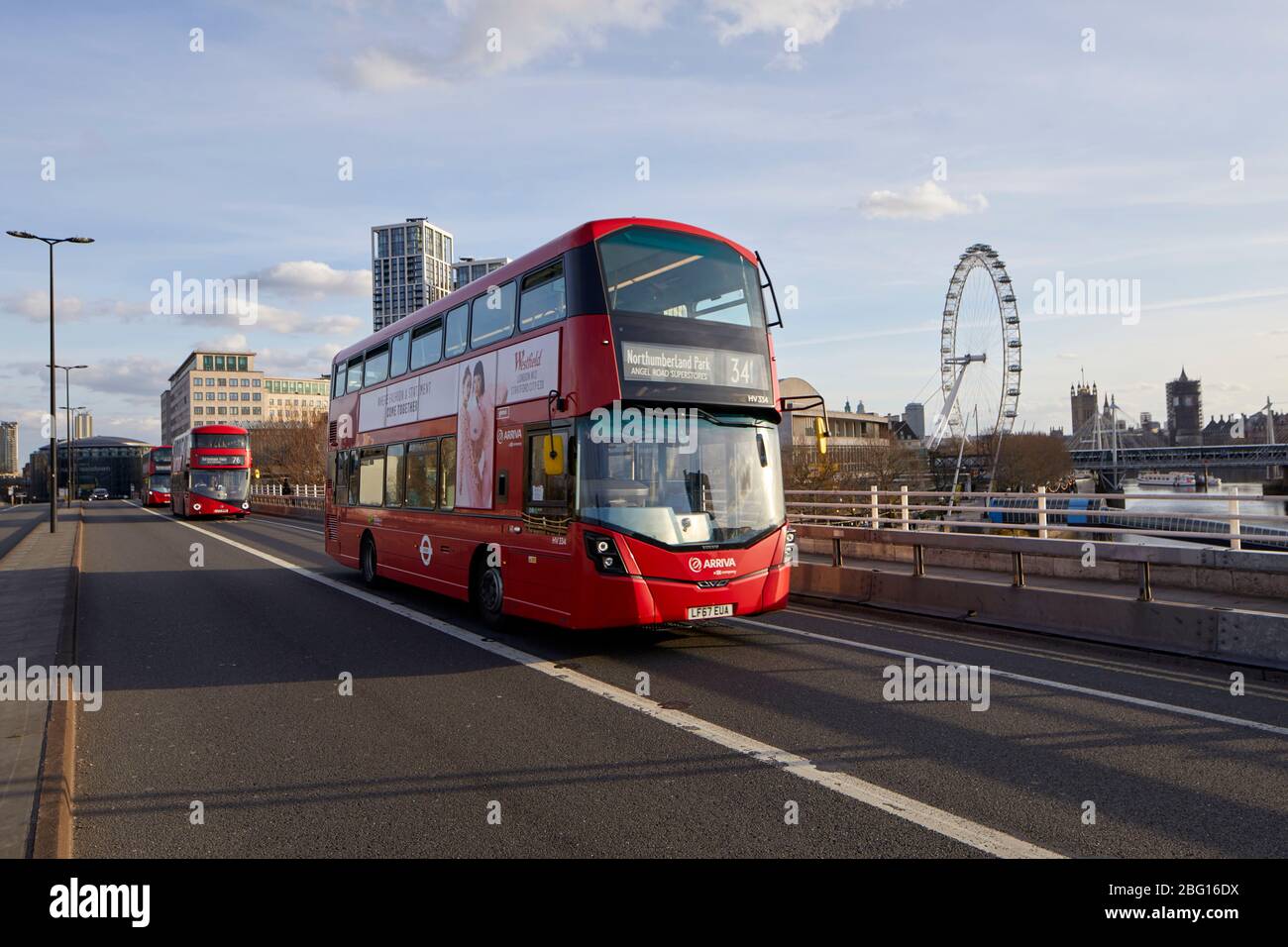 Minimal traffic apart from red buses on Waterloo Bridge during restricted travel of Coronavirus COVID-19 Lockdown in London SE1, England Stock Photo