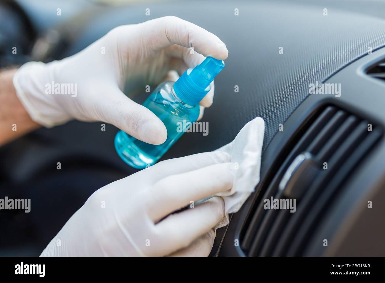 Professional worker using disinfectant and microfiber cloth to clean
