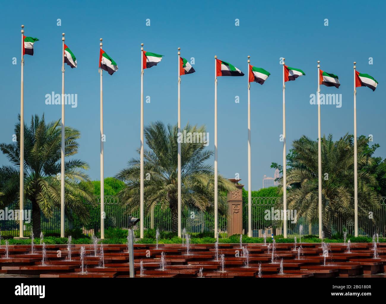 Flags of the United Arab Emirates waving on poles against the blue sky