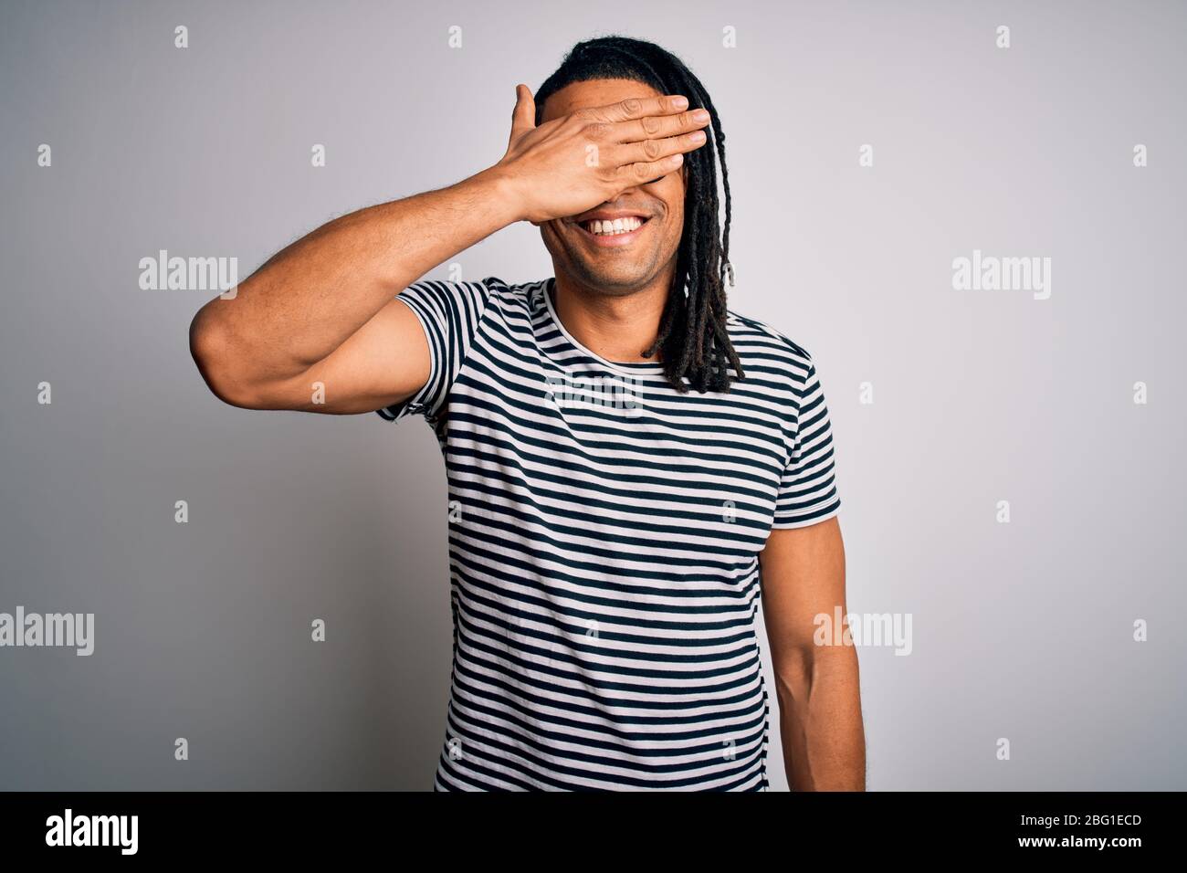 Young handsome african american man with dreadlocks wearing striped t ...