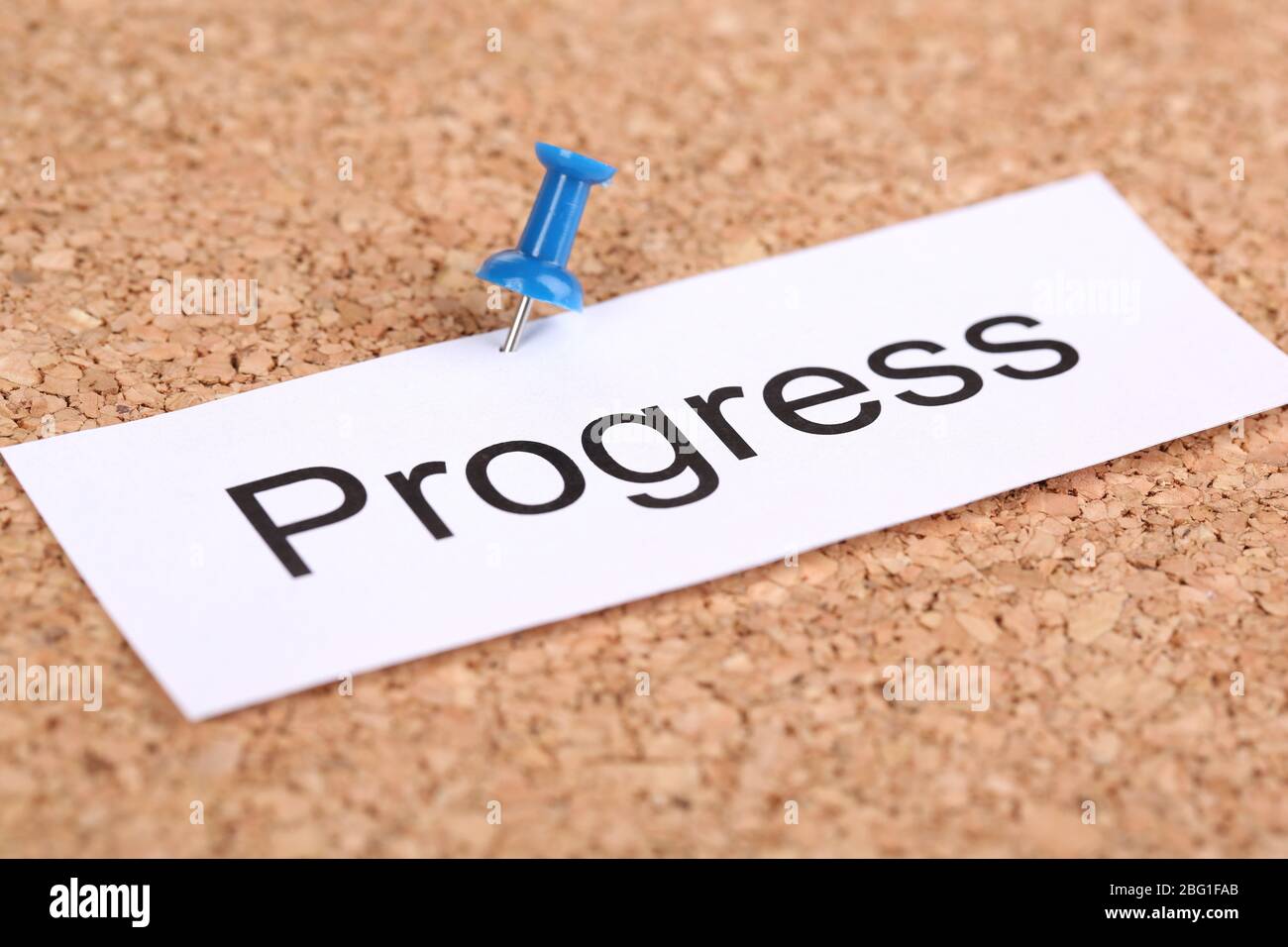 Push pin on paper with word progress on cork board Stock Photo - Alamy
