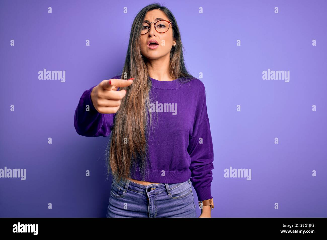 Young beautiful smart woman wearing glasses over purple isolated ...