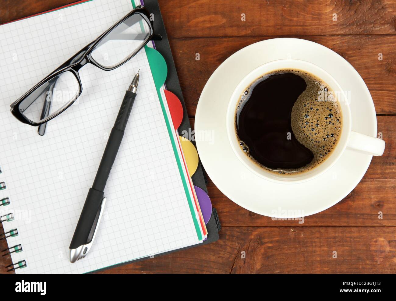 Cup of coffee on worktable covered with documents close up Stock Photo