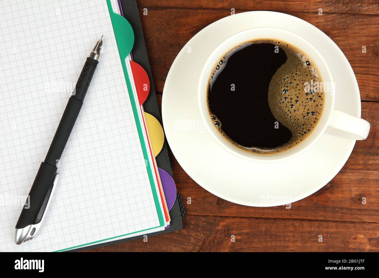 Cup of coffee on worktable covered with documents close up Stock Photo