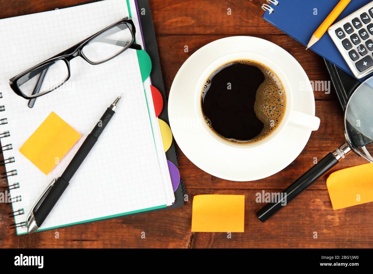 Cup of coffee on worktable covered with documents close up Stock Photo