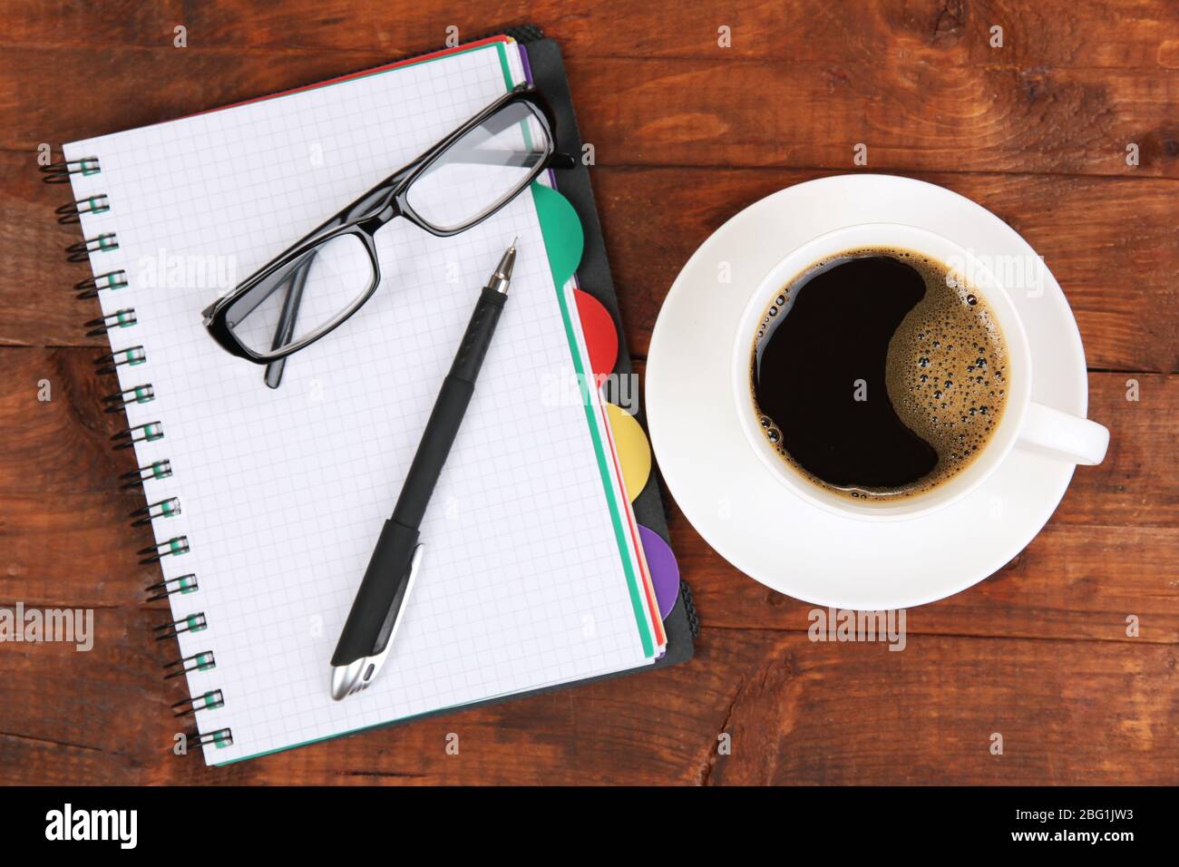 Cup of coffee on worktable covered with documents close up Stock Photo