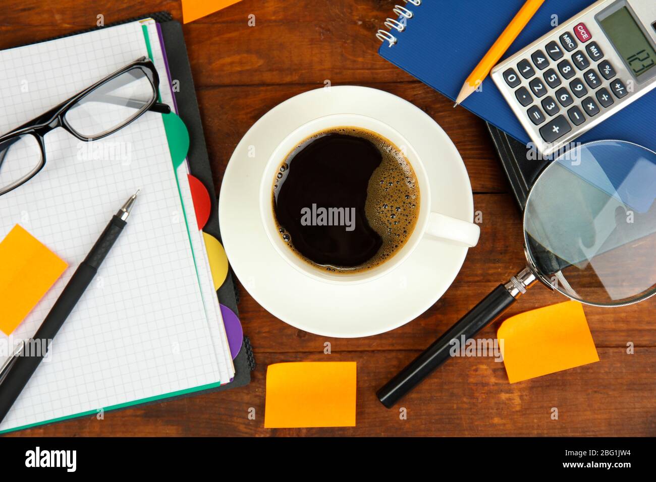 Cup of coffee on worktable covered with documents close up Stock Photo