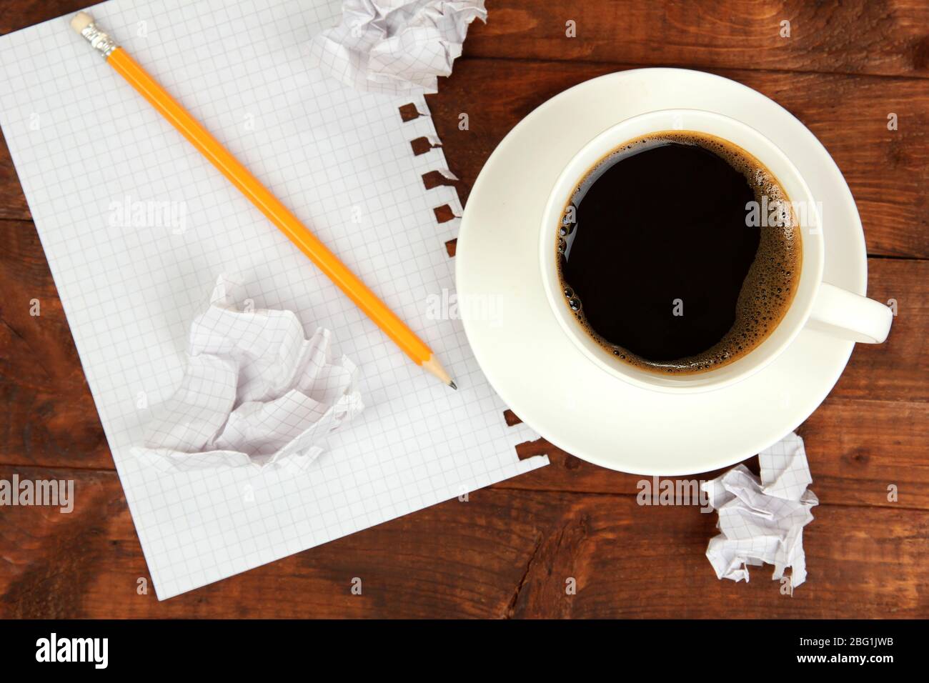 Cup of coffee on worktable covered with documents close up Stock Photo