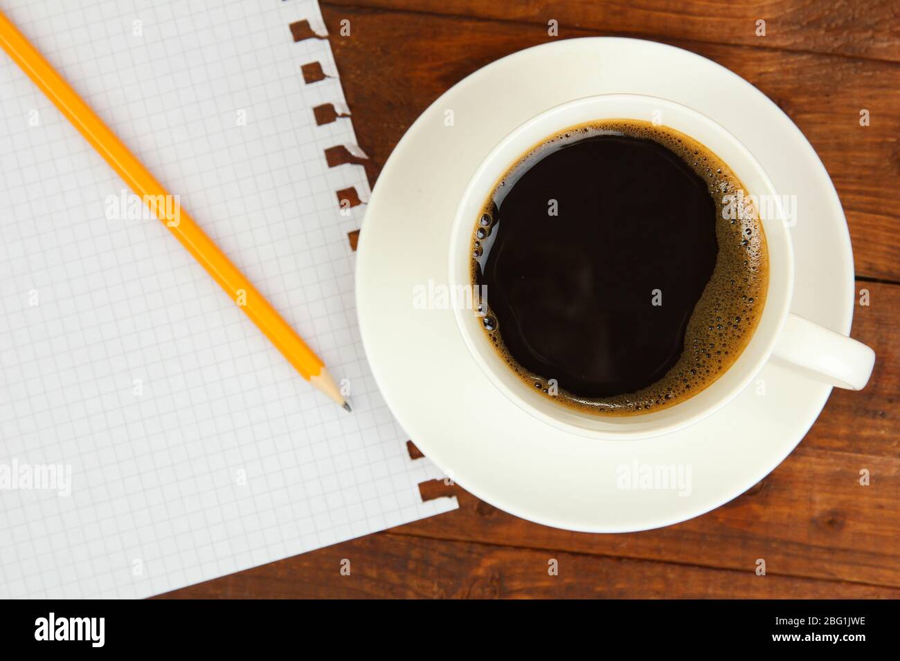 Cup of coffee on worktable covered with documents close up Stock Photo