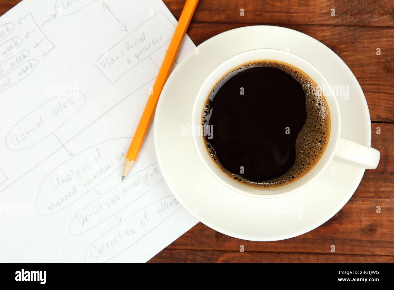 Cup of coffee on worktable covered with documents close up Stock Photo