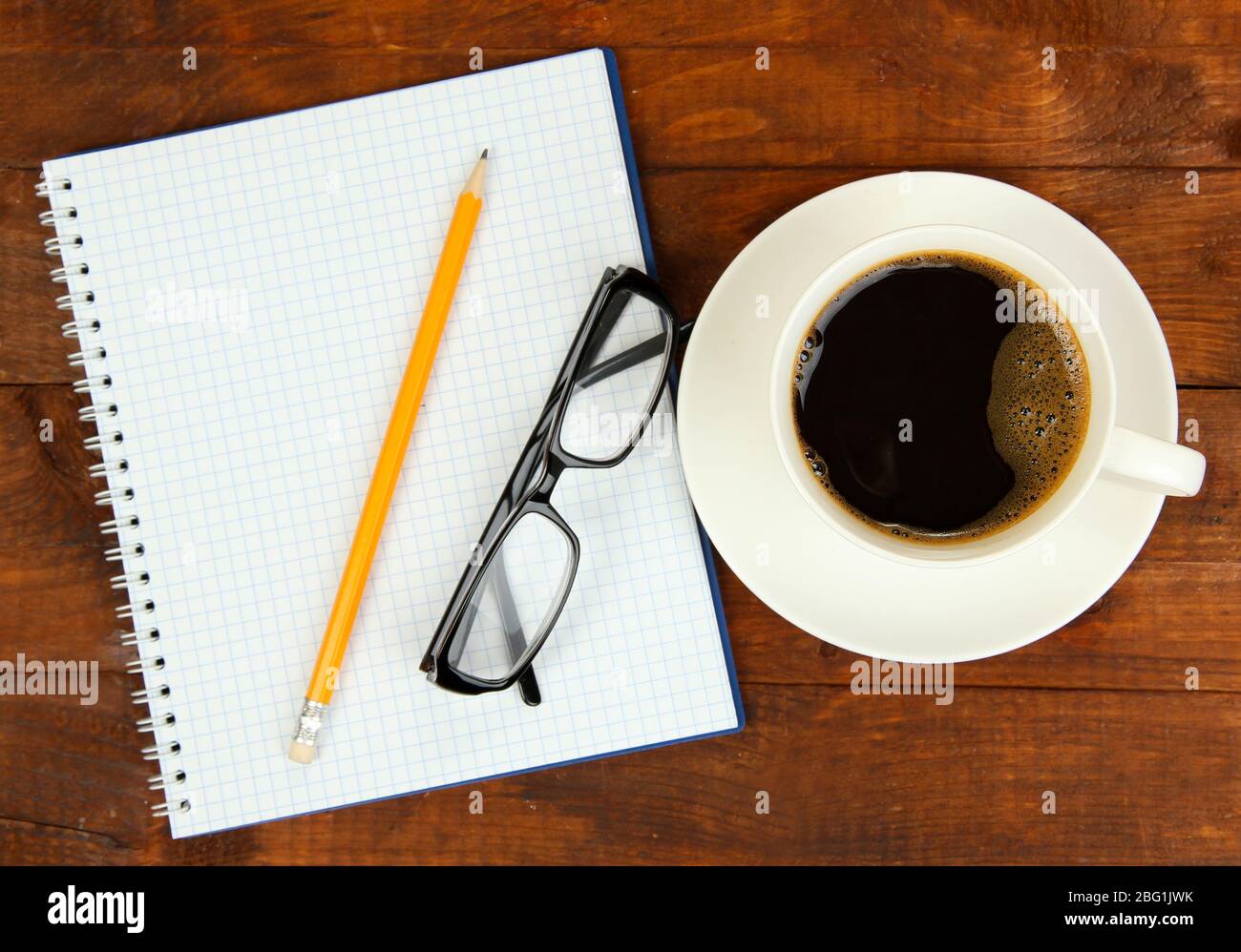 Cup of coffee on worktable covered with documents close up Stock Photo