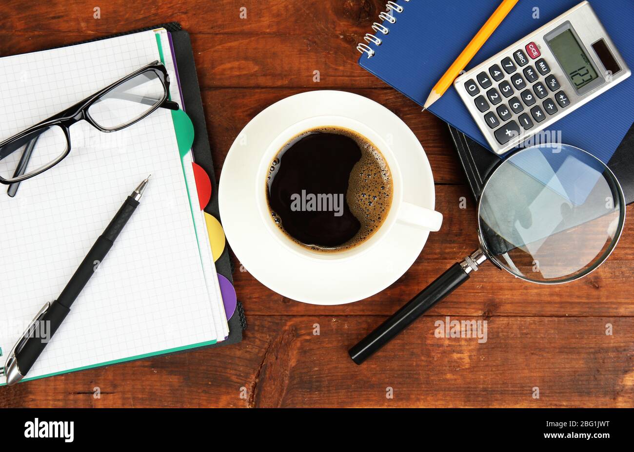 Cup of coffee on worktable covered with documents close up Stock Photo
