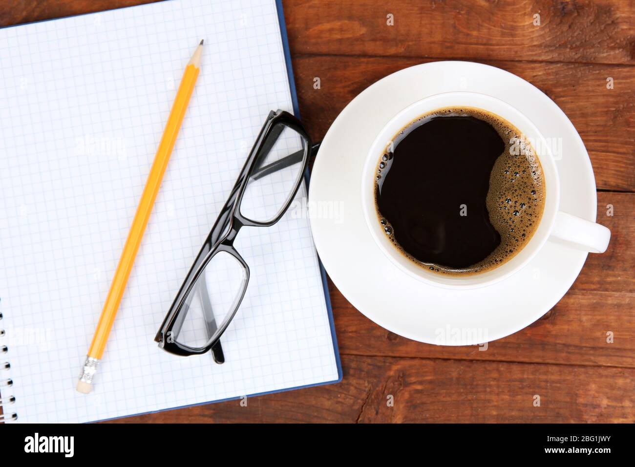 Cup of coffee on worktable covered with documents close up Stock Photo