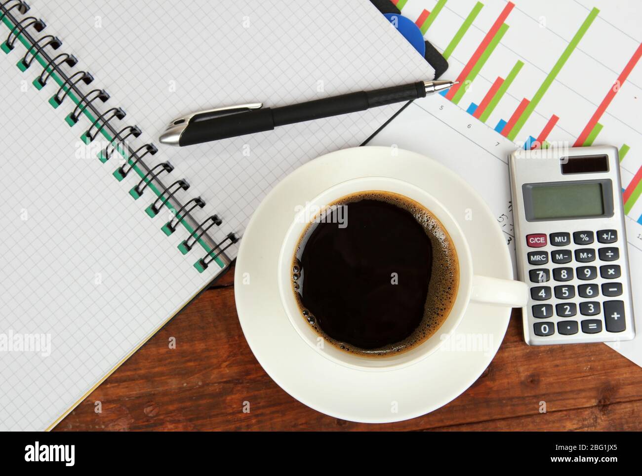 Cup of coffee on worktable covered with documents close up Stock Photo