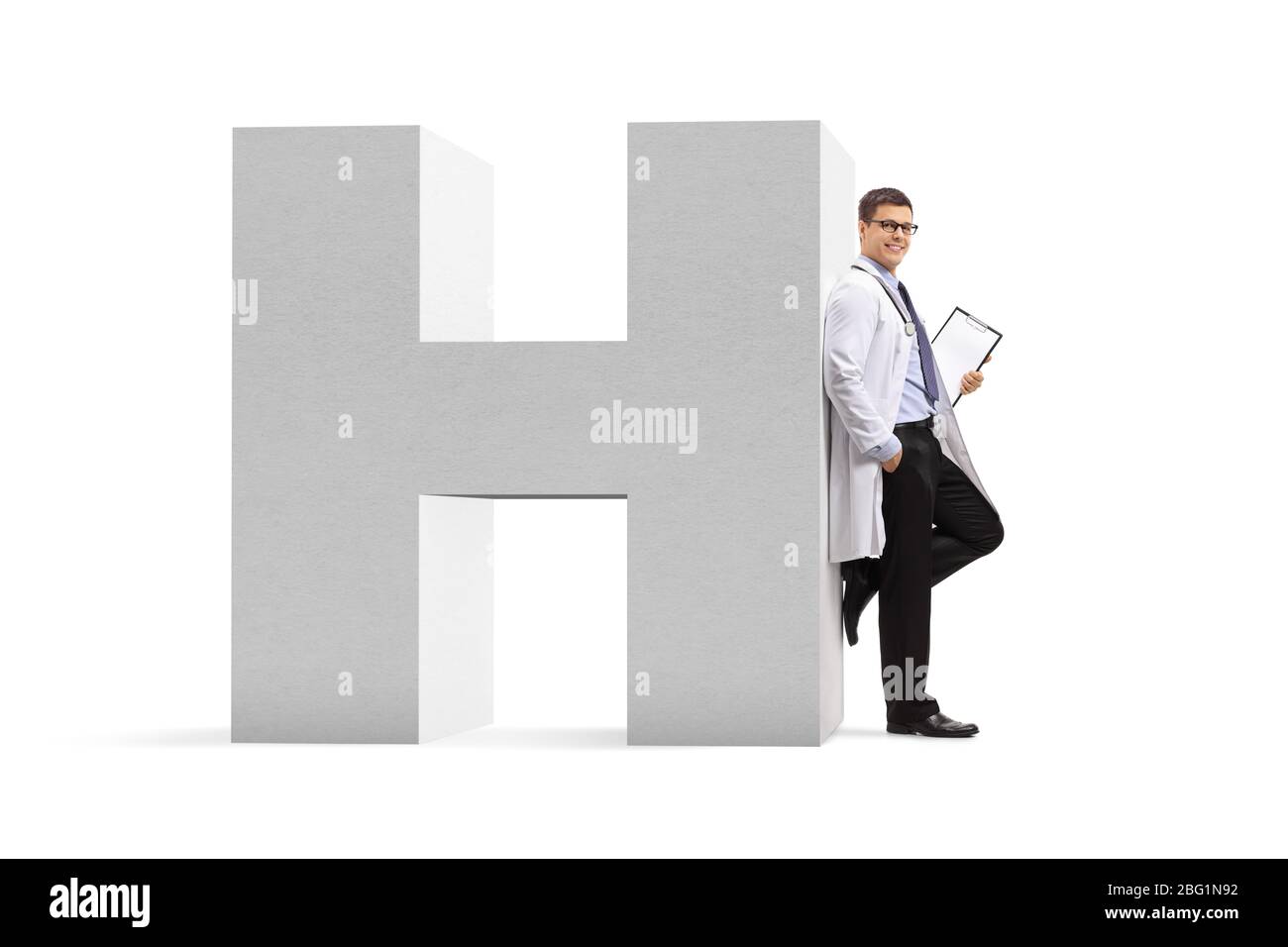 Full length portrait of a doctor leaning on a letter H, a sign for hospital isolated on white background Stock Photo