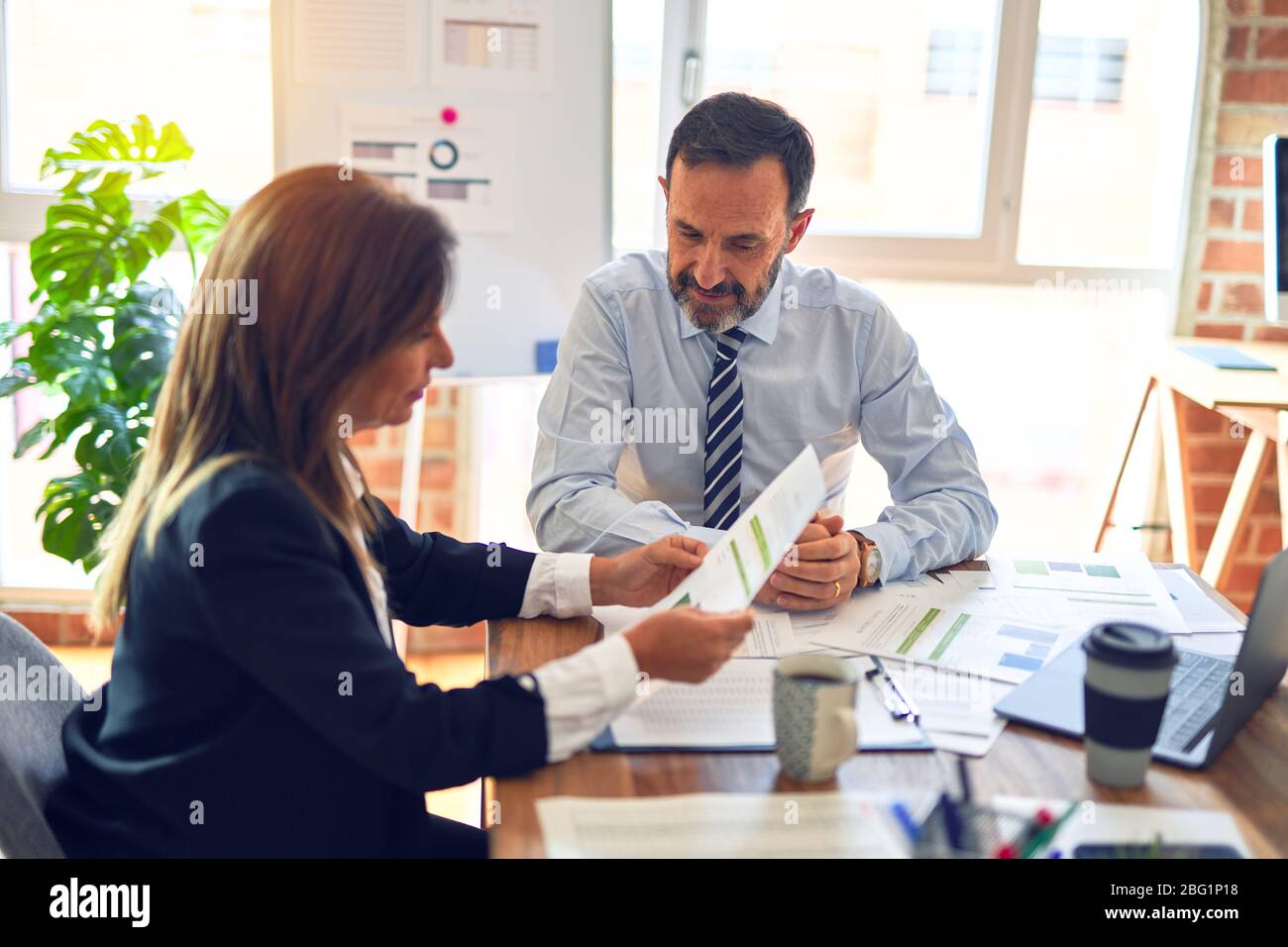 Two middle age business workers smiling happy and confident. Working ...