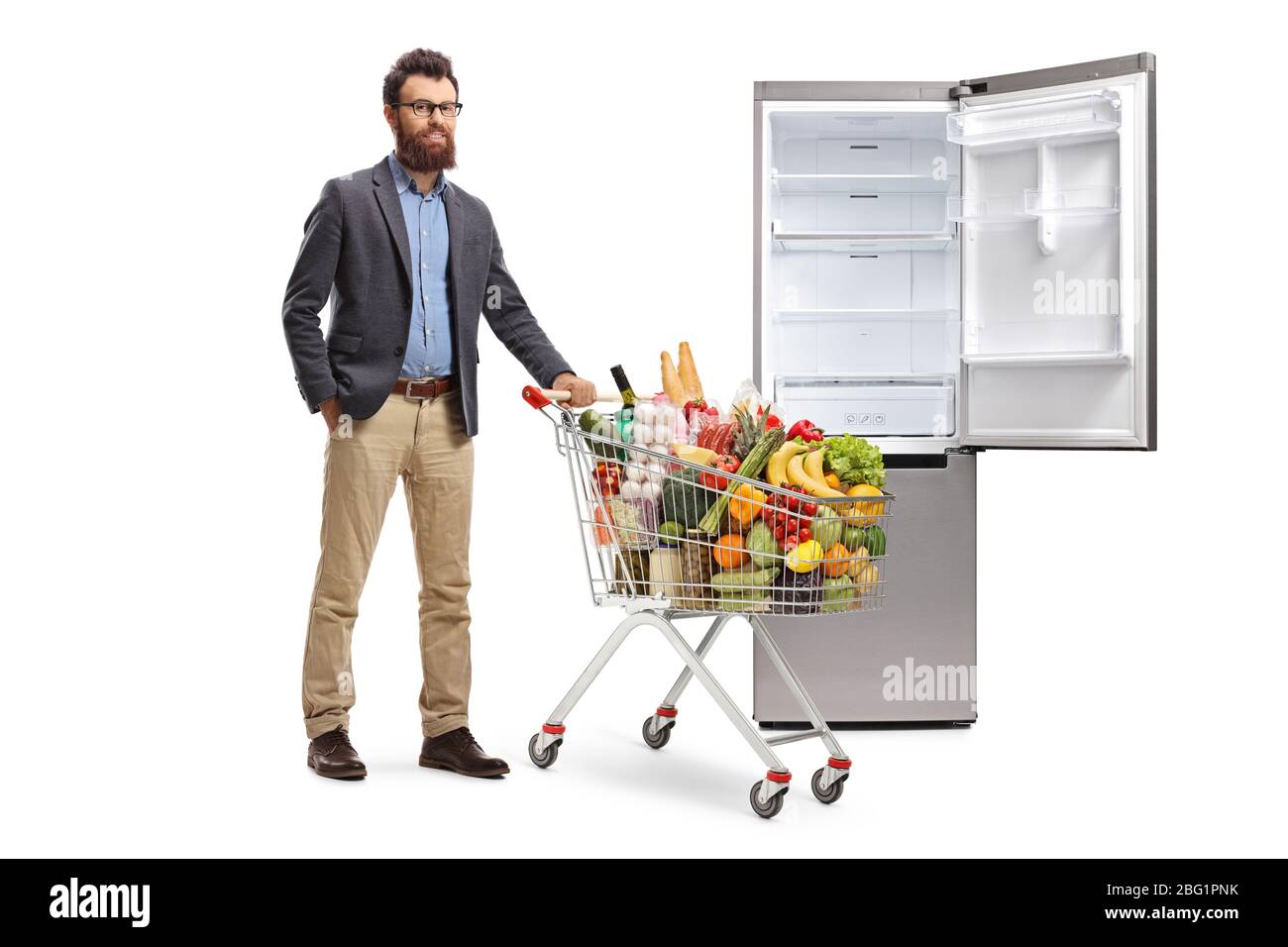 Full length portrait of a bearded man loading a fridge with food supplies isolated on white background Stock Photo