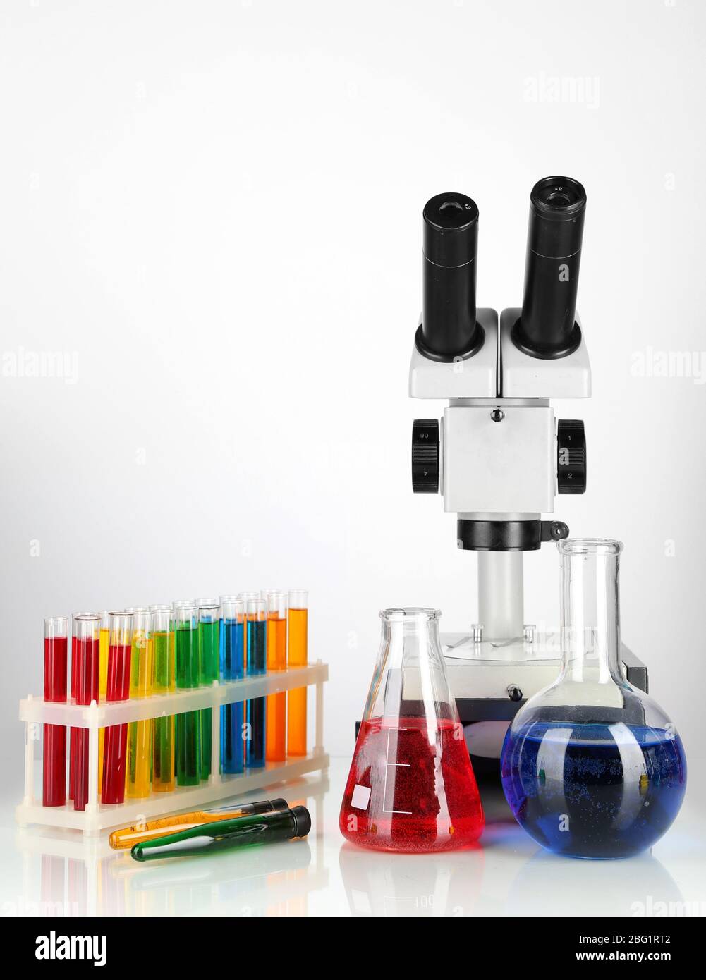 Test tubes with colorful liquids and microscope isolated on white Stock ...