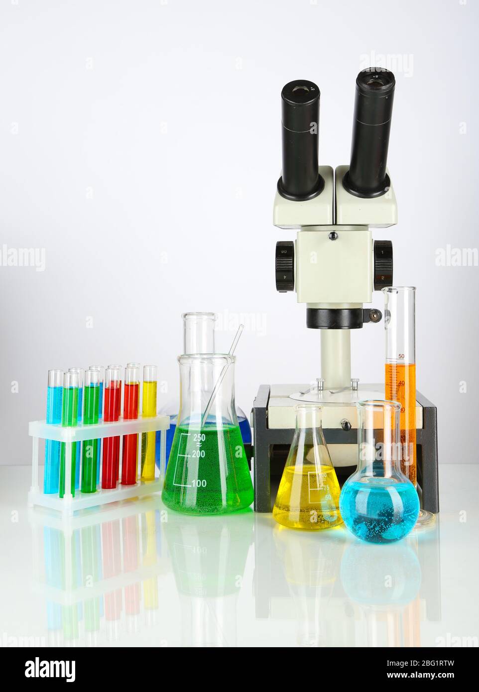 Test tubes with colorful liquids and microscope isolated on white Stock ...