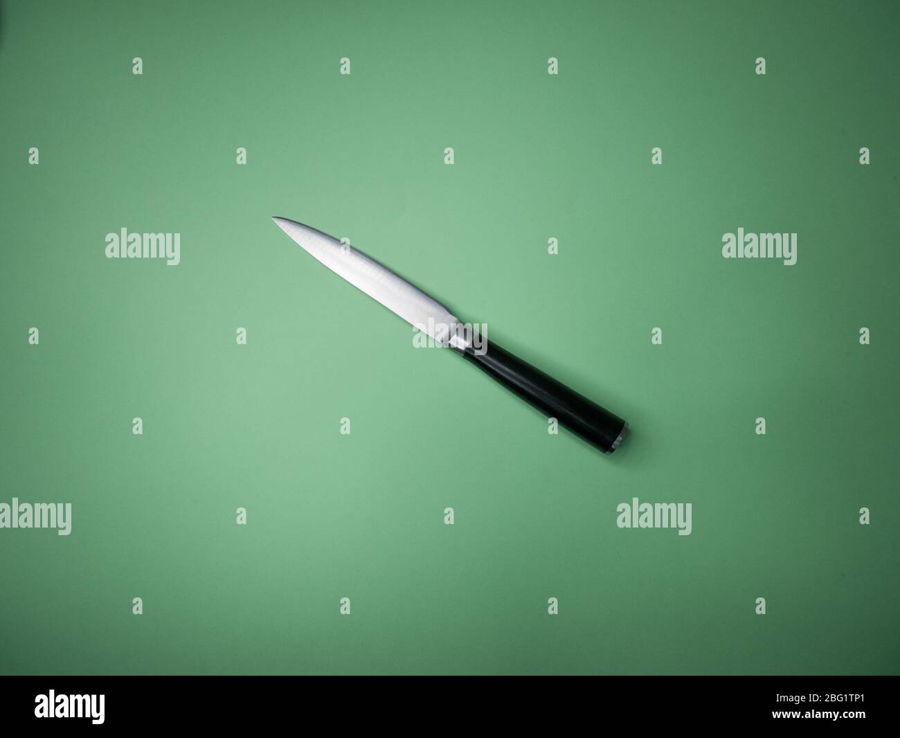 Professional kitchen knife isolated on green background. Stock Photo