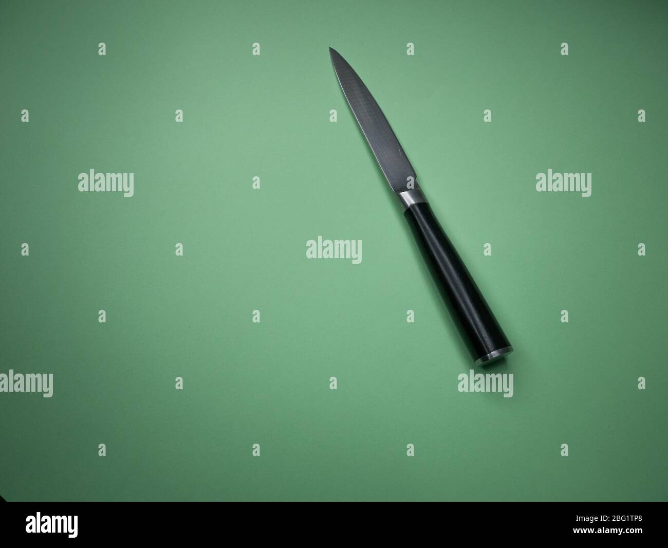 Professional kitchen knife isolated on green background. Stock Photo