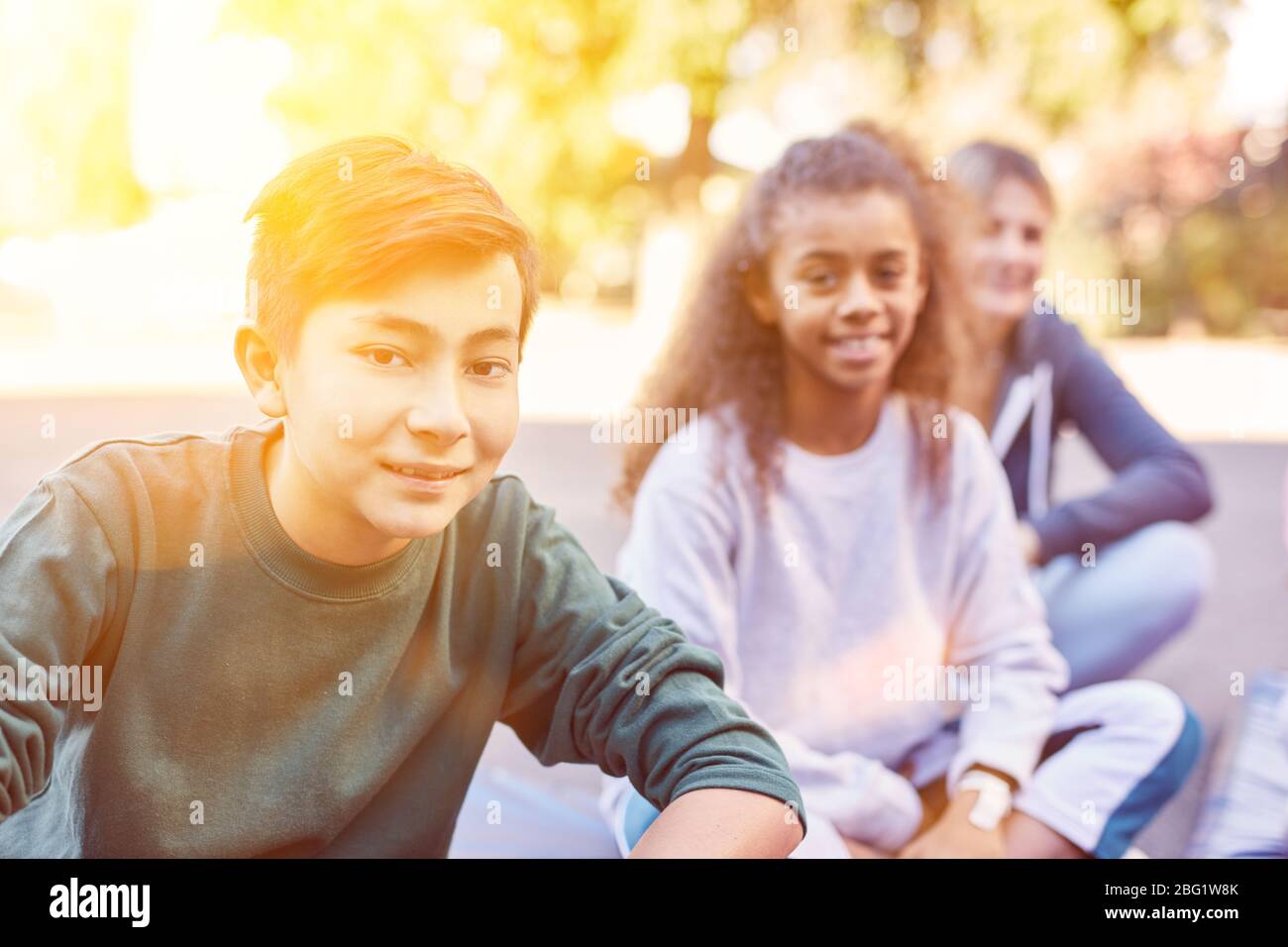 Happy group of kids are sitting on school playground or kids leisure Stock Photo